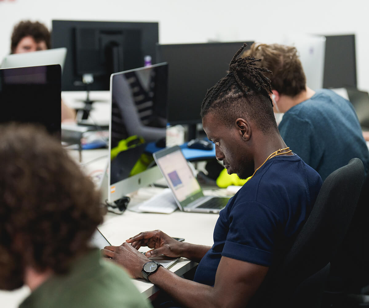 Office workers using computers and laptops in a collaborative environment